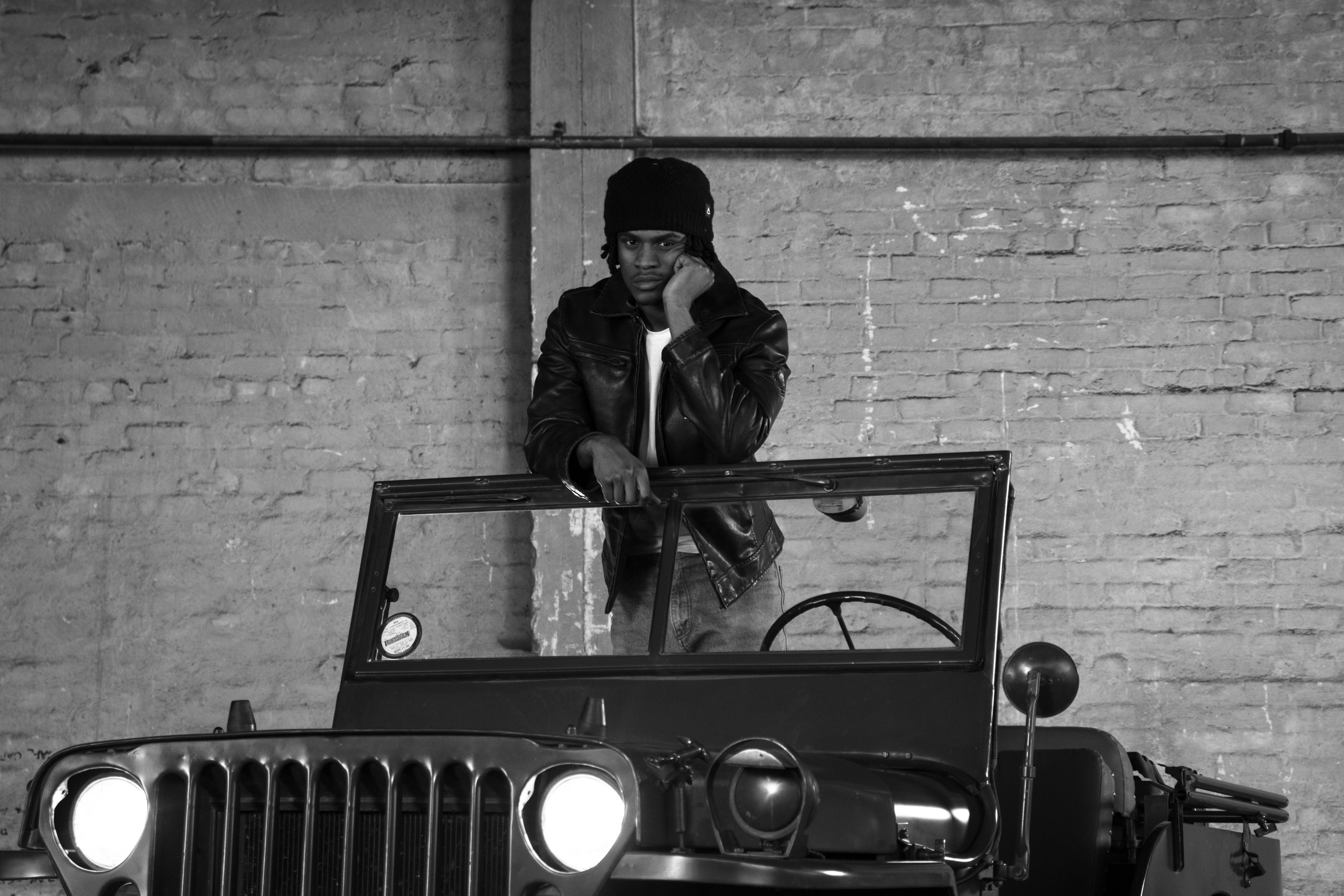 A man in a leather jacket on a willis jeep